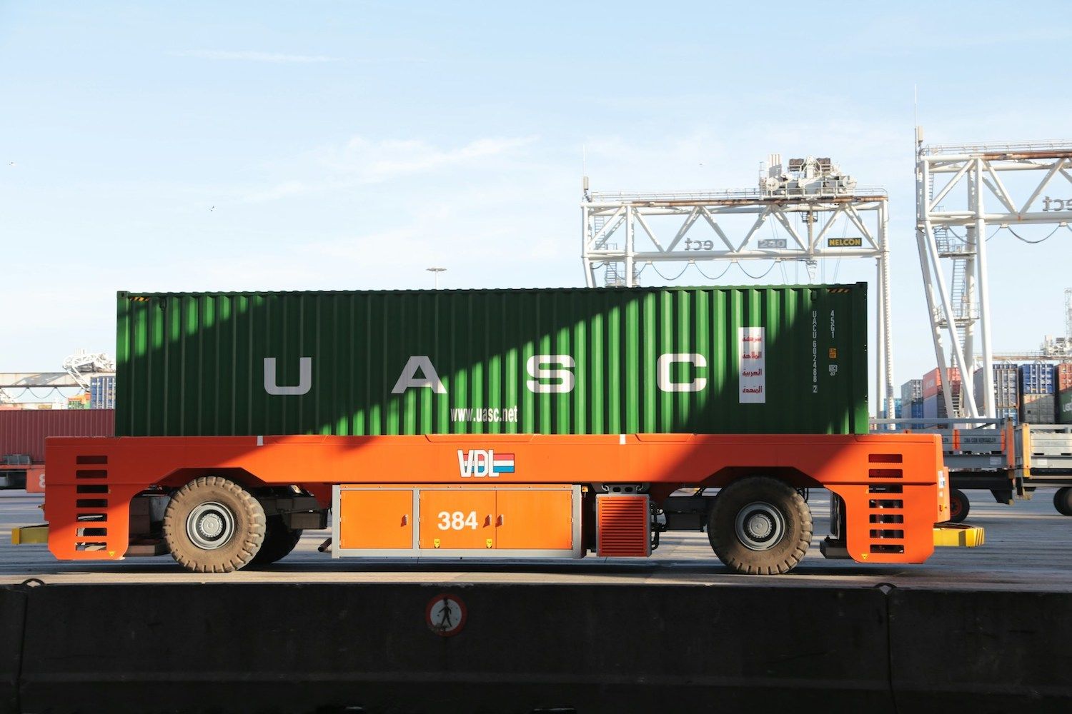 orange and green cargo truck at a container port